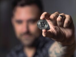 person holding silver bitcoin coin